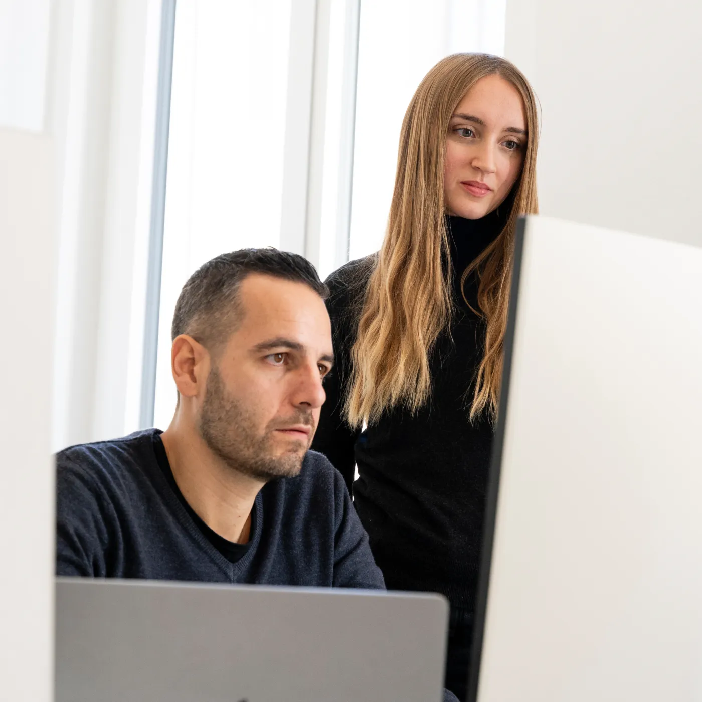 Immagine di un ragazzo e una ragazza che guardano concentrati verso un monitor
