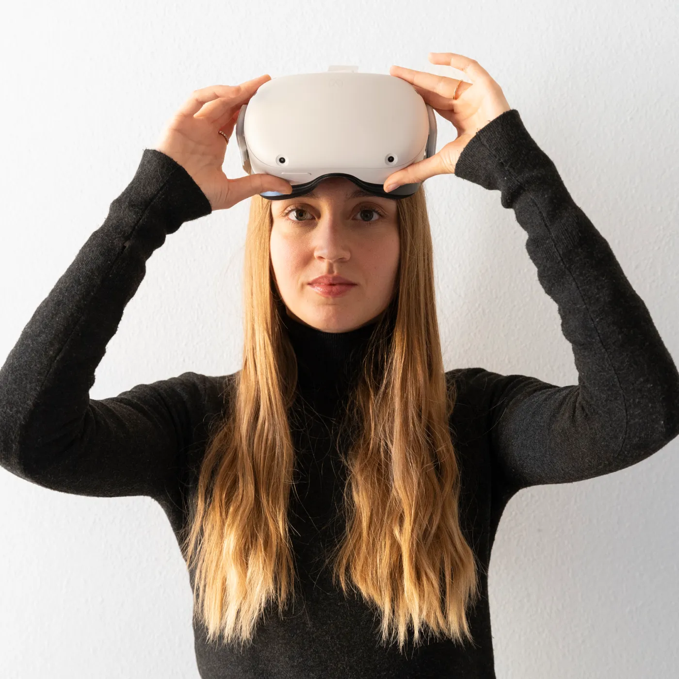Immagine di una ragazza che si toglie il visore oculus per la realtà virtuale.